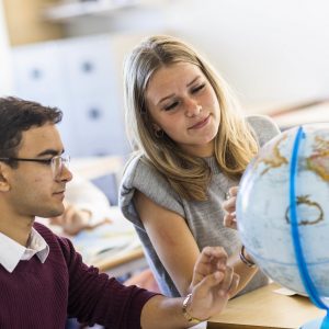 students looking at a globe