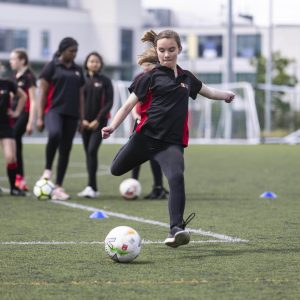 girl kicking a ball